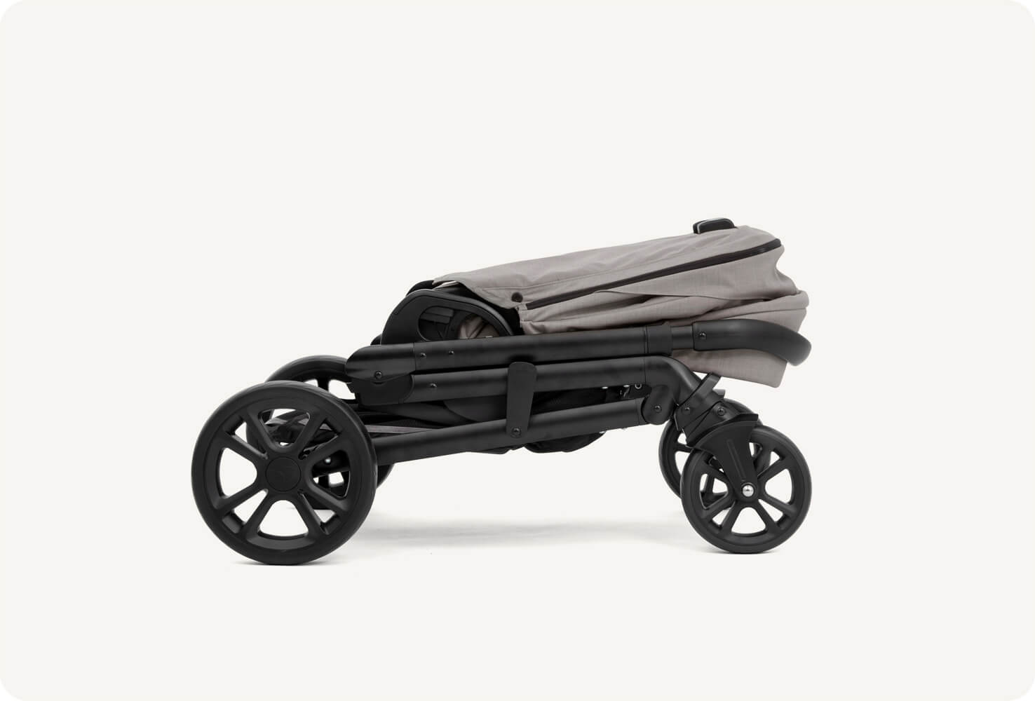 A folded gray Joie Chrome pram in profile.